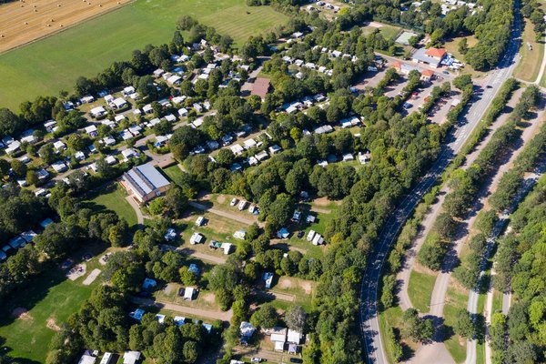 Aus der Luft sieht man, dass der Campingplatz Bostalsee aus mehreren Buchten und über 400 Plätzen besteht und von viel Grün umgeben ist.